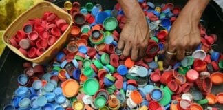 European Energy Teams Up with Novo Nordisk and the LEGO Group for a Greener Future in Plastic Production person hands on assorted color plastic lid lot