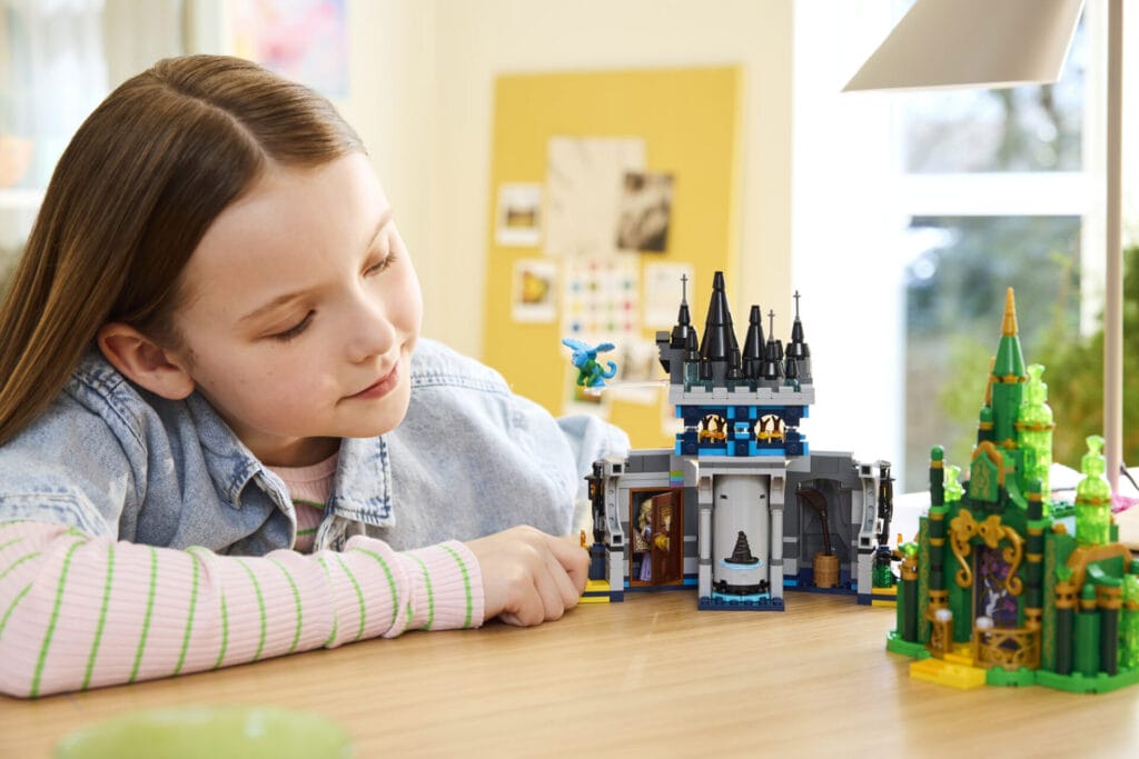 Image of a girl looking and playing with the new LEGO Wicked:For Good Sets 2025 - Emerald castle building set 