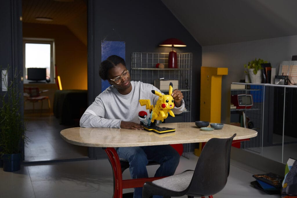 A man builds the new LEGO® Pokémon™ Pikachu and Poké Ball