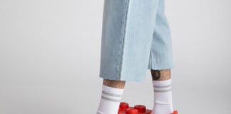 LEGO Crocs Collaboration Is Happening: Brick-Shaped Clogs Are Coming A close up of the new LEGO Crocs collaboration on a mans feet.