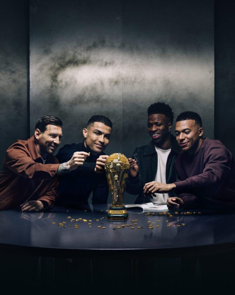 LEGO Editions Football Sets Celebrate Messi, Ronaldo, Mbappé and Vini Jr. Ahead of the World Cup 1 Ronaldo, Mbappé, Messi, and Vini Jr. sit around a LEGO replica World Cup Trophy